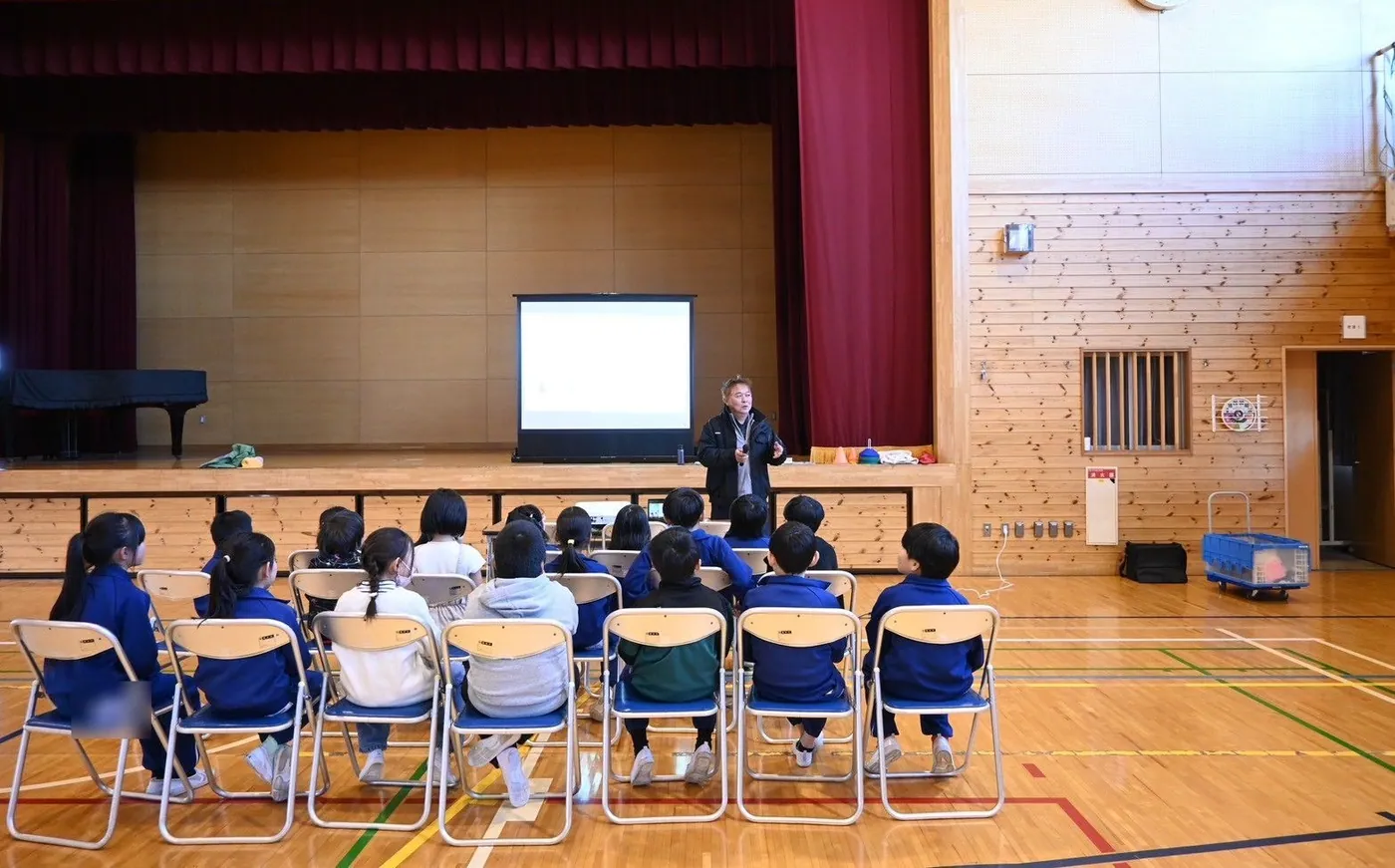 小学生向けの体験会。体育館にスクリーンと椅子を並べ、説明から始めたところ